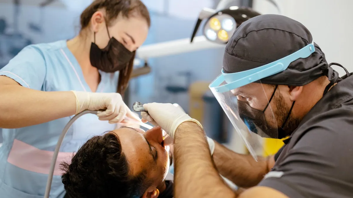 Femeie tânără care tresare la o lingură de înghețată din cauza dinților sensibili, Clinicile Dentalix