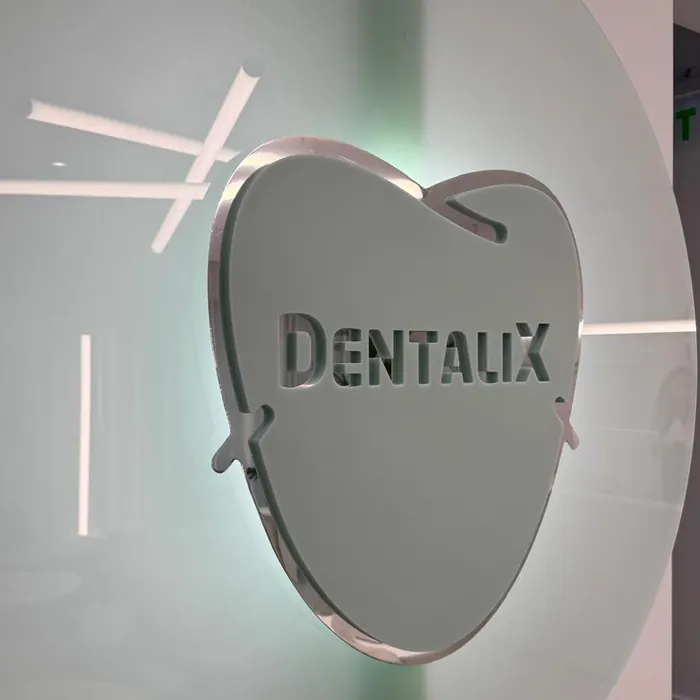 Sigla Dentalix în formă de dinte, pe un panou de sticlă mată, în clinica din Băicoi