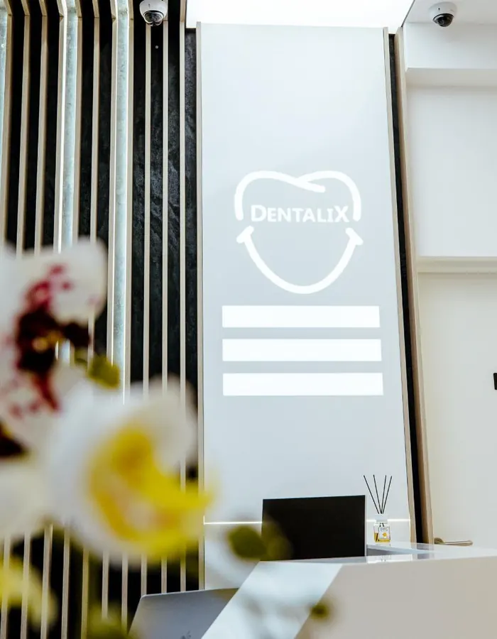 Recepția clinicii Dentalix Topoloveni, cu logo-ul iluminat pe perete și ușa cabinetului de radiologie